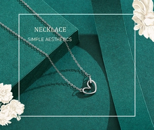 Détail macro du pendentif cœur évidé en argent avec zircons micro-pave sur un collier