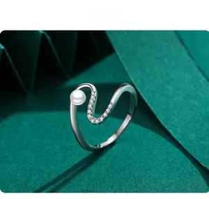 Gros plan détaillé sur une bague vague en argent S925 avec perle et zircons micro-pave