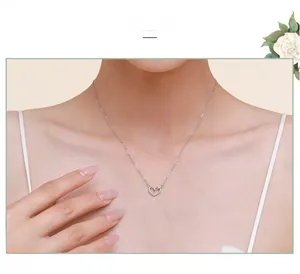 Gros plan d'un collier avec pendentif cœur ajouré en argent S925 porté par un mannequin
