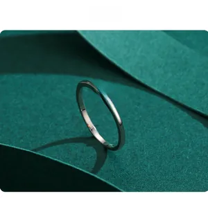Macro shot of silver pear shaped teardrop ring with pave stones on dark green paper