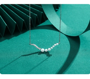 Detail of elegant S925 silver necklace with gradient pearls and zircon arch detail