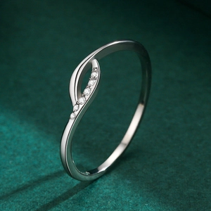 Minimalist s925 silver cross ring with sparkling cubic zirconia on a green background