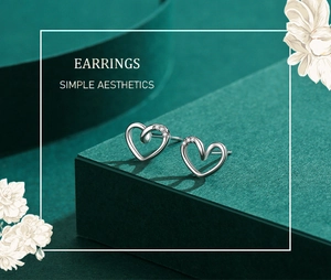 Macro detail of silver hollow heart earrings with twisted design and zircon accents