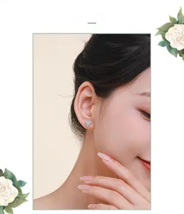 Close-up of S925 sterling silver heart stud earrings with cubic zirconia on female model