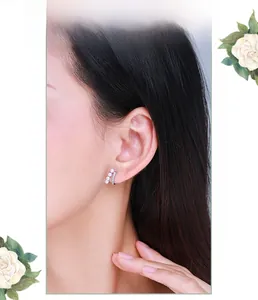 Close-up of S925 silver hoop earrings with pearls and pavé cubic zirconia on a model