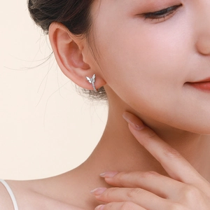 Elegant S925 sterling silver bow earrings with sparkling zircons worn by a female model