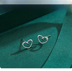 Macro shot of S925 sterling silver heart earrings with micro-inlaid zircon on velvet