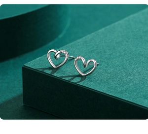 Macro view of S925 sterling silver heart earrings with delicate inlaid small diamonds