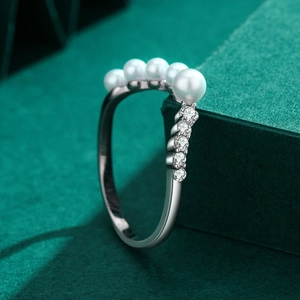 S925 sterling silver V-shape ring with elegant pearls and cubic zirconia on green background