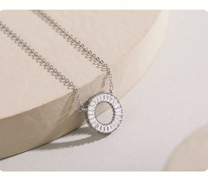 Macro shot of silver daisy circle pendant featuring baguette-cut zircon gemstones