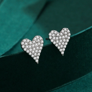 Elegant S925 sterling silver heart earrings with pave-set zircons on green velvet