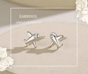 Gros plan sur les boucles d'oreilles avion en argent avec pierres de zircone