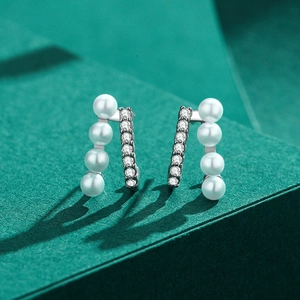 Elegant S925 sterling silver pearl and zircon earrings displayed on a dark platform