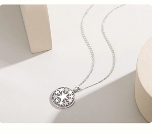 Detailed macro of a hollow circular silver pendant with sparkling inlaid star patterns