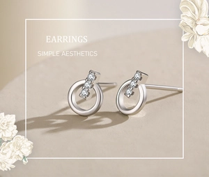 Detail of s925 silver stud earrings with sparkling cubic zirconia on stone background