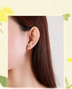 Gros plan de petites boucles d'oreilles avion en argent sterling S925 sur un mannequin