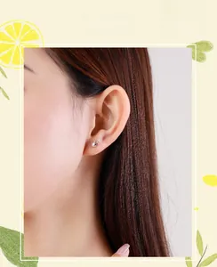 Close-up of S925 sterling silver crown stud earring with zircon on model ear