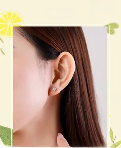 Detail shot of square S925 sterling silver micro-pave stud earrings on model's ear
