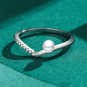 Elegante anello a V in argento S925 con perla bianca e zirconi scintillanti su sfondo verde