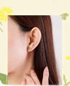Detailed view of s925 sterling silver curved ear studs with shimmering inlaid diamonds