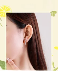 Détail de boucles d'oreilles en argent s925 avec zircons carrés, ronds et en poire