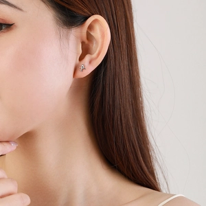 Boucles d'oreilles avion en argent sterling S925 minimalistes portées par un mannequin