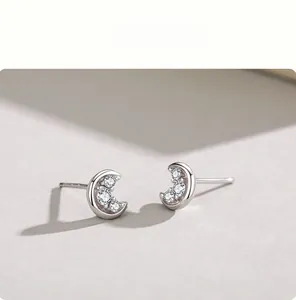 Macro shot of S925 sterling silver crescent moon earrings with cubic zirconia inlay