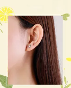 Close-up of S925 sterling silver leaf stud earring worn on a female model's ear