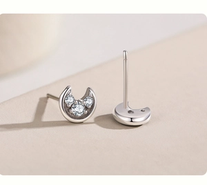 Macro shot of S925 sterling silver moon earrings with three sparkling inlaid zircons