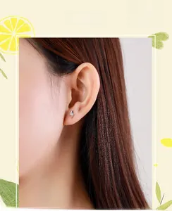 Close-up of minimalist s925 sterling silver lightning bolt stud earring on a model