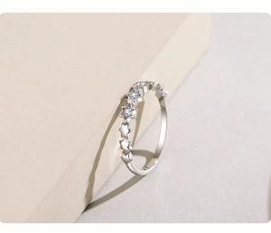 Detailed close-up of s925 silver star ring with micro-set zircon stones on beige block