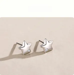 Macro detail of S925 sterling silver star stud earrings with tiny inlaid zircon crystal
