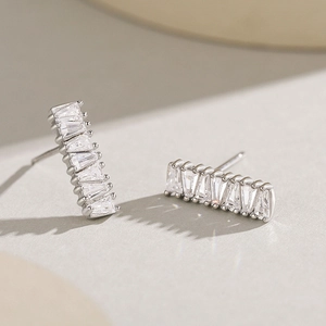 Boucles d'oreilles en argent s925 avec diamants baguettes sur fond texturé
