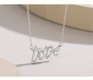 Macro detail of the LOVE letter pendant with micro-paved cubic zirconia on a S925 silver chain