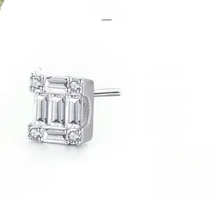 Macro shot of geometric S925 silver stud earrings featuring baguette cut cubic zirconia