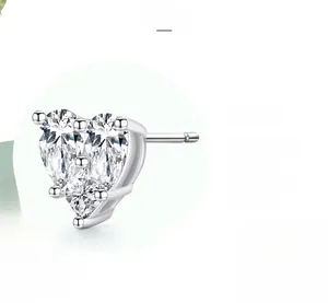 Close-up of heart-shaped silver earrings featuring intricate multi-stone pave settings