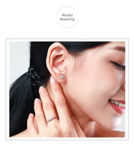 Nahaufnahme der S925 Sterling Silber Gänseblümchen Ohrstecker und passender Ring am Modell