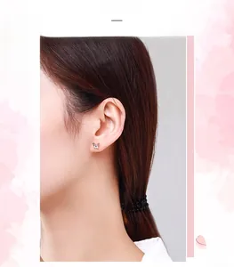 Vue détaillée de boucles d'oreilles papillon en argent portées par un mannequin asiatique