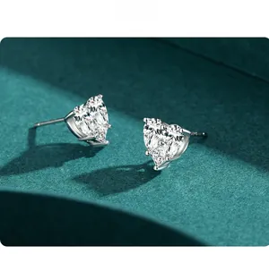 Close-up of s925 silver heart stud earrings with sparkling cubic zirconia on dark background