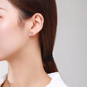 Boucles d'oreilles papillon en argent S925 avec zirconiums portées sur un mannequin
