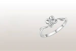 Macro detail of S925 silver four-leaf clover ring with sparkling center stone and twisted band