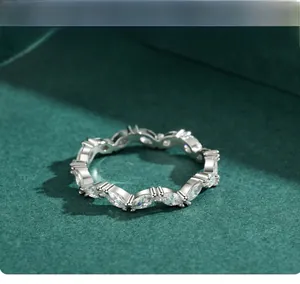 Macro view of sterling silver marquise cut zircon eternity ring on luxury green surface