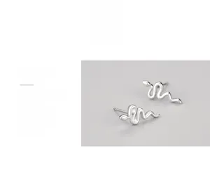 Macro shot of silver snake earrings featuring high-polish finish and fluid curved details