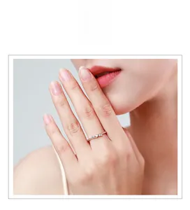 Gros plan d'une bague minimaliste en argent S925 avec trois zircons portés au doigt