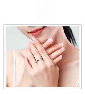 Gros plan sur une bague coeur en argent s925 avec diamants micro-pavés sur le doigt