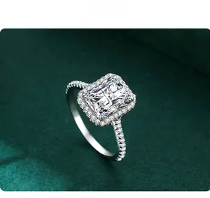 Macro shot of 3ct radiant cut faux diamond ring with halo setting on a green textured background