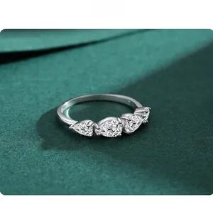 Macro detail of teardrop-cut stones set in S925 sterling silver ring on green velvet