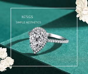 Macro detail of pear-cut 3 carat diamond ring on textured dark green steps with floral art