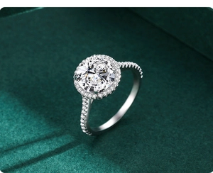 Close-up of a 5-carat halo round cut diamond ring on a luxury green velvet background