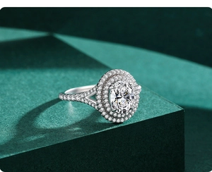 Macro detail of oval cut double halo diamond engagement ring on a dark green pedestal